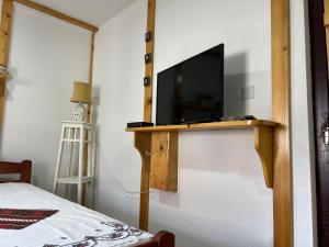 a bedroom with a television on a wooden stand at Etno kuća Danica in Senje
