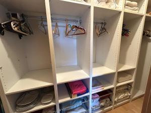 a walk in closet with white shelving at Bijou Homestay I - Room w Balcony, Mountain & Garden Views in Mieders