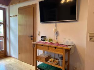 a room with a table with a television on the wall at Bijou Homestay I - Room w Balcony, Mountain & Garden Views in Mieders +13 photos