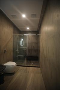a bathroom with a glass shower and a toilet at Nalluri Garden Resort in Kottapatnam +10 photos