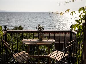 a wooden bench sitting next to a body of water at Olive Press Hotel & Apartments in Mythimna