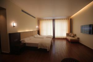 a bedroom with a bed and a couch and a television at Nalluri Garden Resort in Kottapatnam