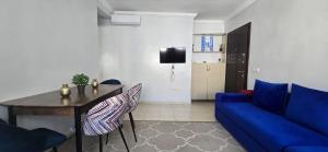 a living room with a blue couch and a table at Fnideqrelax in Fnidek