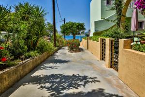 a walkway with flowers and plants and a building at Haraki De Sol Beach Apartments in Haraki +35 photos
