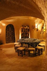 a room with a table and chairs in a cave at Kirkit Hotel in Avanos