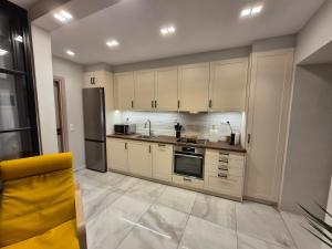 a kitchen with white cabinets and a yellow chair at Hydra's Jewel in Hydra