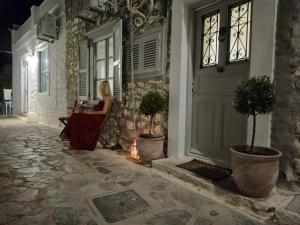 a woman sitting at a table in front of a door at Hydra's Jewel in Hydra