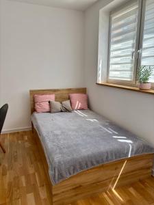 una cama en una habitación con ventana en Apartament Bławatny Busko-Zdrój, en Busko-Zdrój