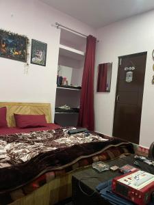 a bedroom with a bed and a red curtain at the kasar devi stays in Almora +8 photos
