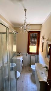 a bathroom with a chandelier and a toilet and a sink at Casetta in Versilia in Viareggio +12 photos