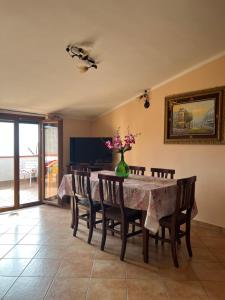 LentiscosaにあるLa Casa del Lentiscoのテーブルと椅子、花瓶に花が飾られたダイニングルーム