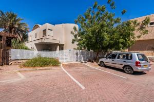 a car parked in a parking lot in front of a building at הקונכייה in Eilat