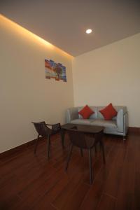 a living room with a couch and two chairs and a table at Nalluri Garden Resort in Kottapatnam