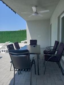 a patio with chairs and a table and a ceiling fan at Z House kuća za odmor in Blagaj