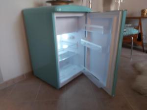a blue refrigerator with its door open in a room at La Bandiera Blu in La Spezia