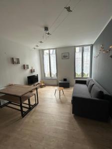 a living room with a couch and a table at Chez Noémie in Saintes