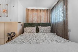 a bedroom with a large bed and a window at הקונכייה in Eilat