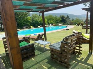a view of a swimming pool with a wooden pergola at Colle Sul Lago in Cingoli
