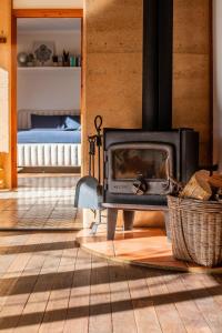 einen Kamin im Wohnzimmer mit einem Bett in der Unterkunft Stirling Creek Cottage in Stirling