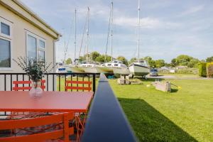 un patio con mesa, sillas y barcos en Restful Riverside Retreat, en Christchurch