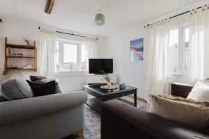 Una sala de estar con dos sofás y un televisor. en Restful Riverside Retreat, en Christchurch