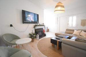 a living room with a couch and a tv on the wall at Coastal Family & Pet friendly home in Ettalong Beach in Ettalong Beach