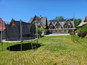 einen Hof mit einem Trampolin vor einem Haus in der Unterkunft Pokoje Gościnne Staszelówka in Małe Ciche