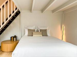 a bedroom with a large white bed and a staircase at Cloud Stylish flat with jacuzzi near city center in Annecy
