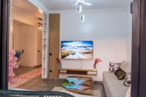 Una sala de estar con un sofá y un cuadro en la pared. en Villa loujain, en Marrakech