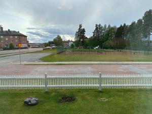 a white fence in front of a park at Centralt lägenhet i Sveg in Sveg