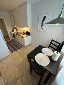 a dining room table with two chairs and a kitchen at Centralt lägenhet i Sveg in Sveg
