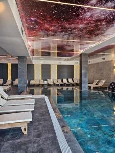 a room with a swimming pool with a universe painted on the ceiling at Harmony, Residence Hill A85 in Kopaonik