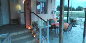 eine Veranda mit Tisch und Stühlen in der Unterkunft VILA SOFi in Néa Karyá