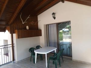a white table and chairs on a patio with a table and a glass door at Pokoje u Czarka in Wasilków