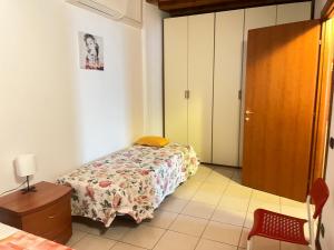 a small bedroom with a bed and a door at Apartments Orio in Orio al Serio