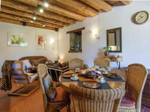 a room with a table with chairs and a clock at Romantic cottage with shared swimming pool in Roussines