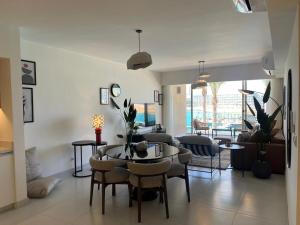 ein Wohnzimmer mit Tisch und Stühlen in der Unterkunft Sea View 3 Bedroom in Marassi North Coast Azur 207 in El-Alamein