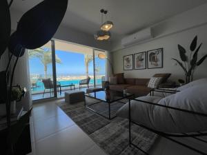 ein Schlafzimmer mit einem Bett und ein Wohnzimmer mit einem Pool in der Unterkunft Sea View 3 Bedroom in Marassi North Coast Azur 207 in El-Alamein