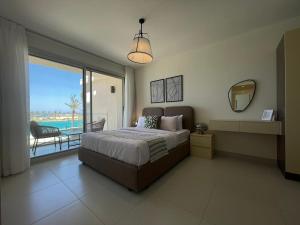 ein Schlafzimmer mit Bett und Blick auf das Meer in der Unterkunft Sea View 3 Bedroom in Marassi North Coast Azur 207 in El-Alamein + 17 Fotos