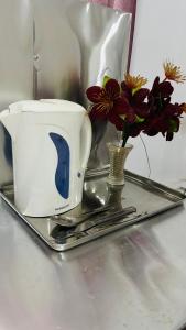 un grille-pain et un vase avec des fleurs sur un plateau dans l'établissement Southern Breeze Homestay Weligama, à Walliwala East