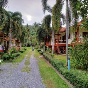 a dirt road in front of a resort with palm trees at Lamai viking bungalow in Koh Samui