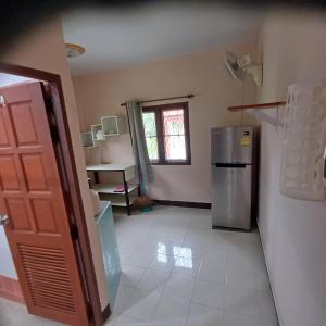 a kitchen with a refrigerator and a room with a window at Lamai viking bungalow in Koh Samui