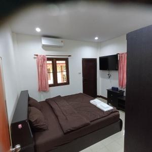 a bedroom with a bed and a flat screen tv at Lamai viking bungalow in Koh Samui