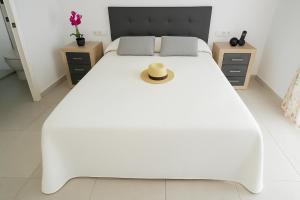 サン・ファン・デ・ロス・テレロスにあるVilla Centauroの白いベッド(上に帽子付)