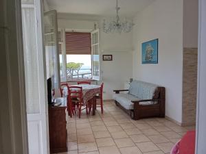 a living room with a table and chairs and a couch at holiday house MAURIZIO in Formia