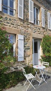 two chairs and a table in front of a building at Ty Dahouet Bretagne in Pléneuf-Val-André