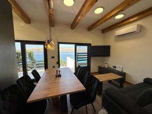 a dining room with a wooden table and chairs at Beachfront Villa Amfora with Pool in Karlobag