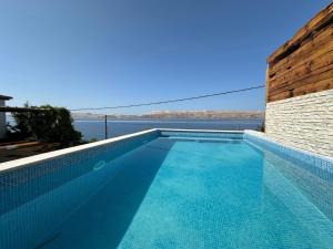 a swimming pool with a view of the water at Beachfront Villa Amfora with Pool in Karlobag