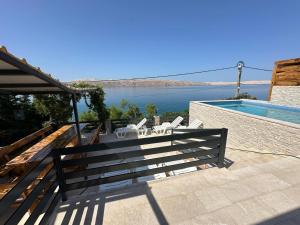 a patio with a bench and a view of the water at Beachfront Villa Amfora with Pool in Karlobag