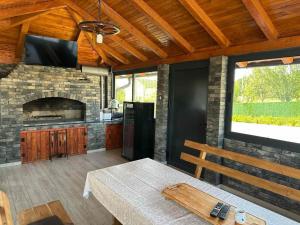 Una cocina con una mesa y una chimenea de piedra. en Art Residence, en Tuzla